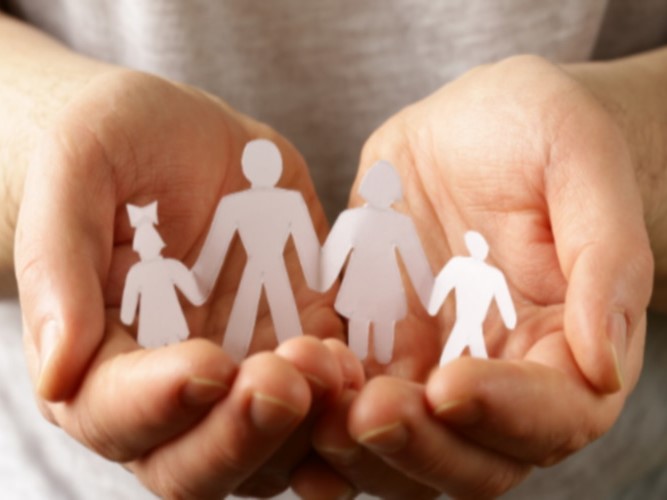 Manos con familia hecha de recortes deapel